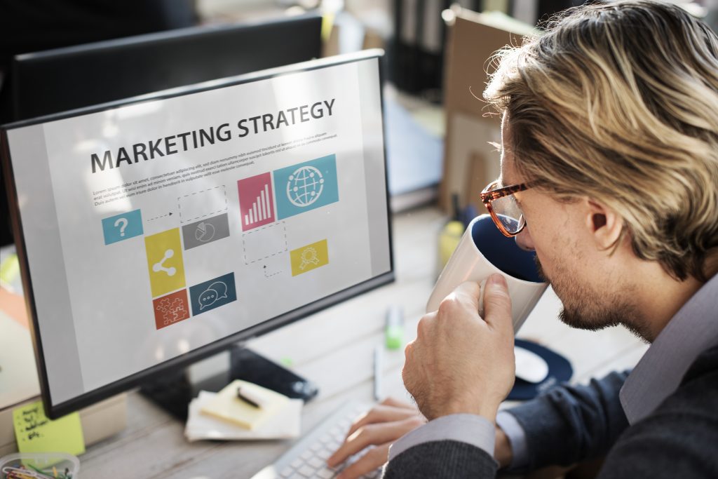 closeup-caucasian-man-drinking-coffee-with-computer-screen-showing-marketing-strategy
